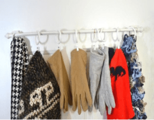 A rack of gloves and scarves hanging on the wall.