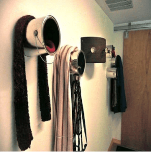 A wall with several hats and scarves hanging on it.