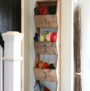 A wall mounted shelf with numbered bins for yarn.